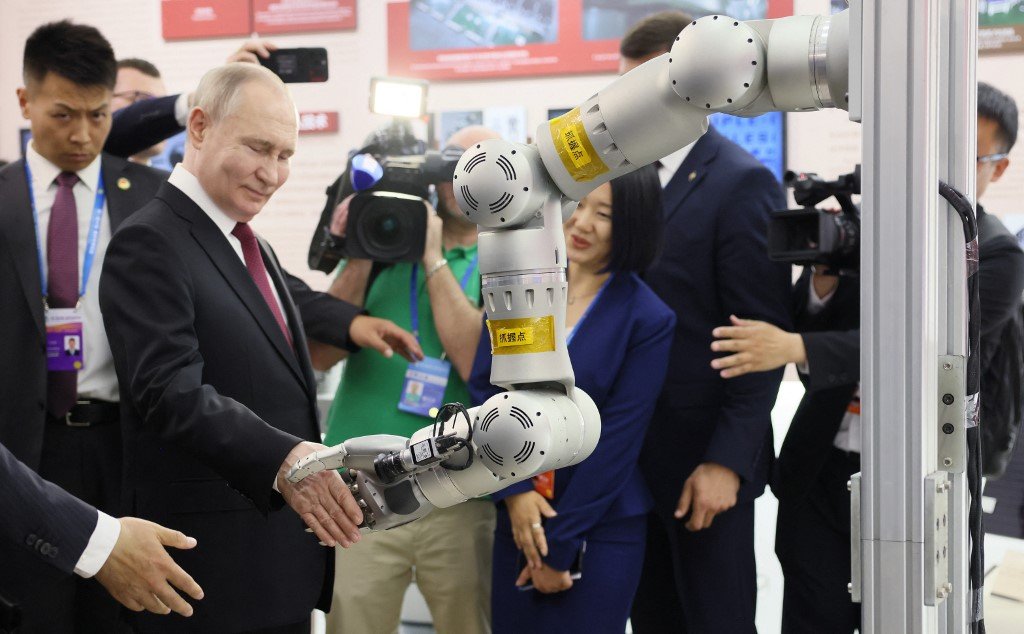 普京到哈尔滨工业大学参观，与该校研制的机械手臂握手。该机械臂上带有大量传感器，能代替太空人在舱外工作。（图取自俄罗斯卫星通讯社/法新社）
