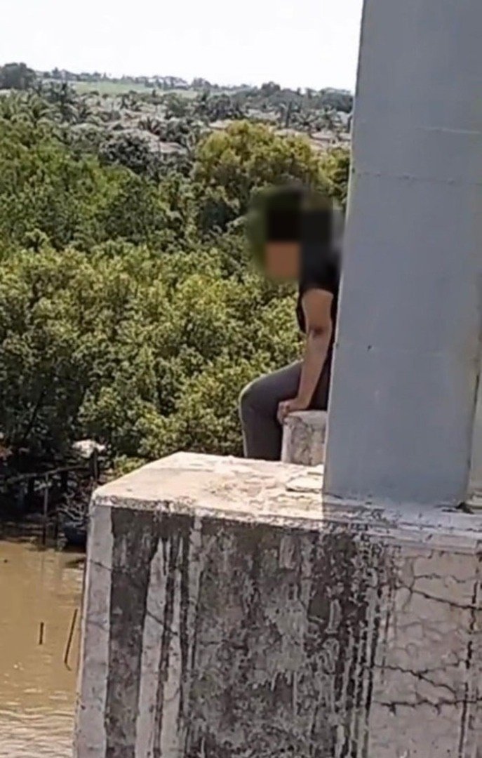 女子独自一人坐在桥上，企图跳桥轻生。