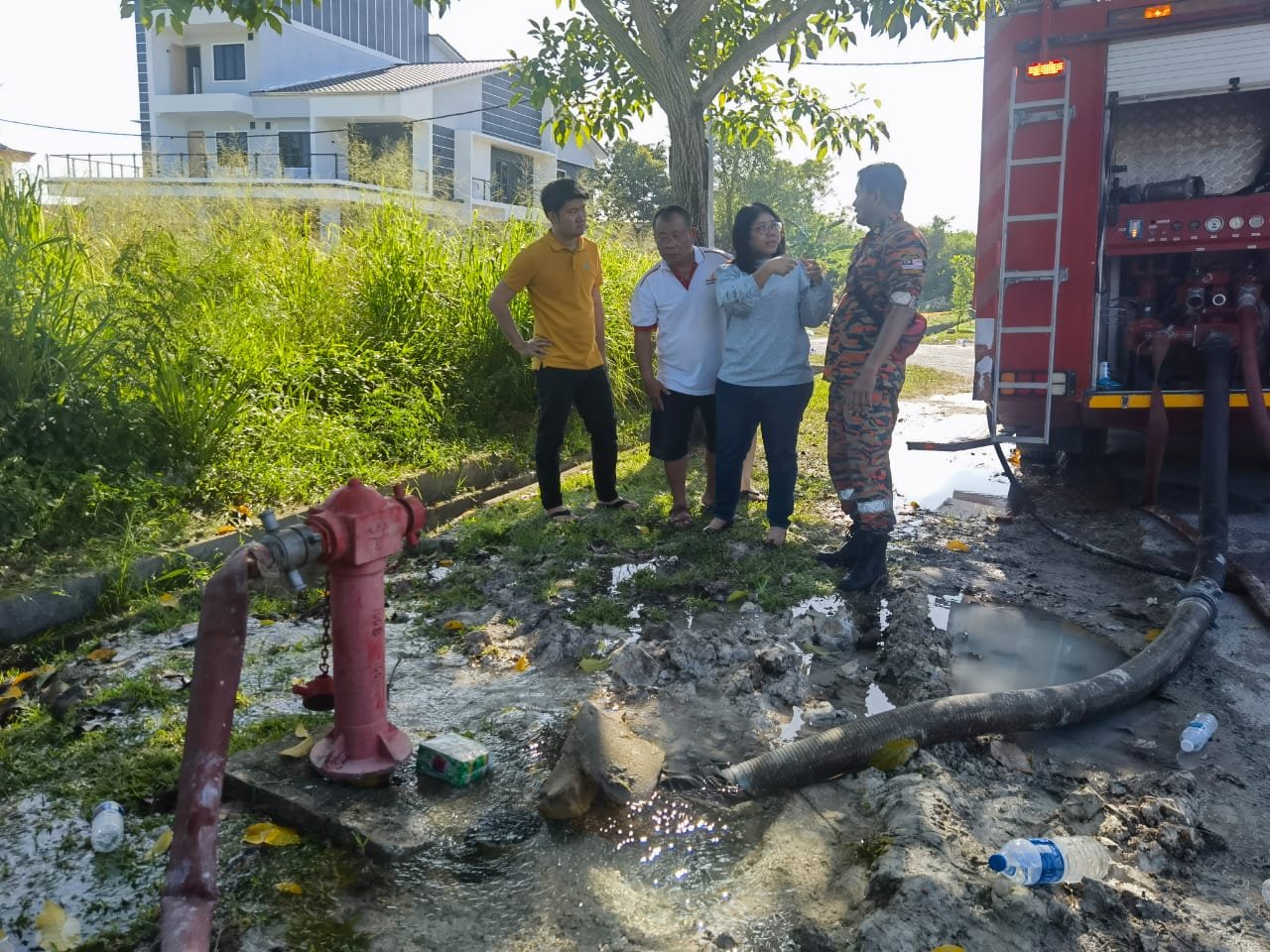 黄渼沄（左3）向消拯员反映消防栓被指水压低的问题。