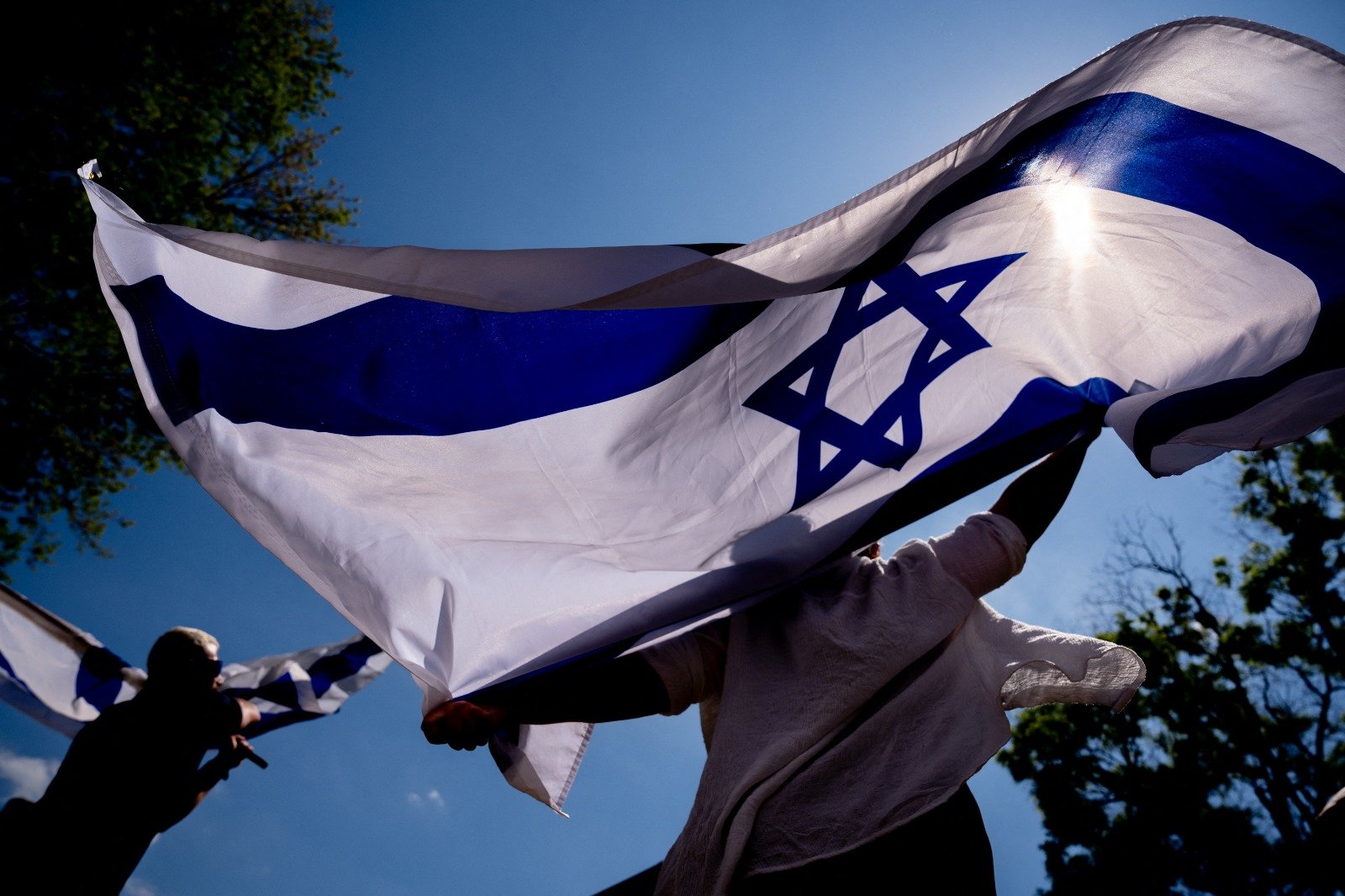 5月2日在乔治华盛顿大学举行的反对校园反犹太主义的集会上，来自弗吉尼亚州的罗卡和华盛顿的Israeli Matan Showstack一边跳舞，一边挥舞著巨大的以色列国旗。（图取自法新社）