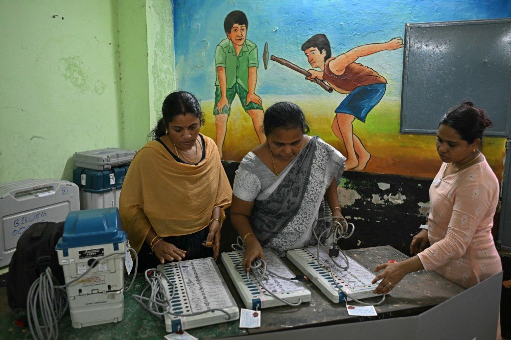 周四在金奈（也称清奈），印度大选第一阶段投票前夕，选举官员在一个投票站安装及检查电子投票机 (EVM)。（图取自法新社）