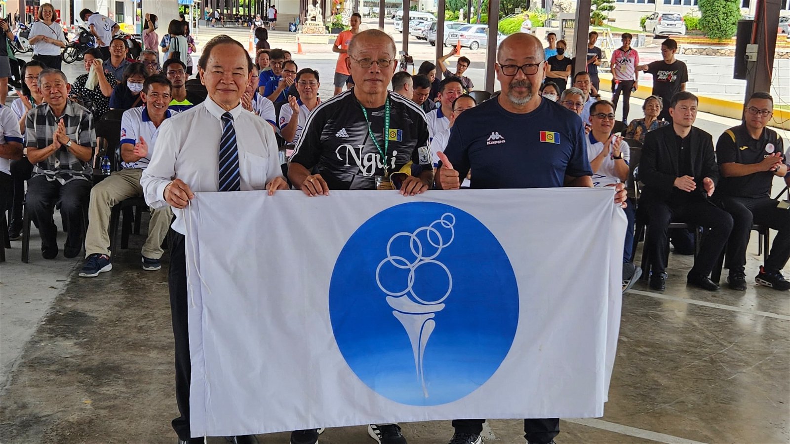 陈大锦（左起）把全国独中足锦赛旗帜移交下一届主办学校，沙巴崇正中学的代表梁新汉及余国伟。