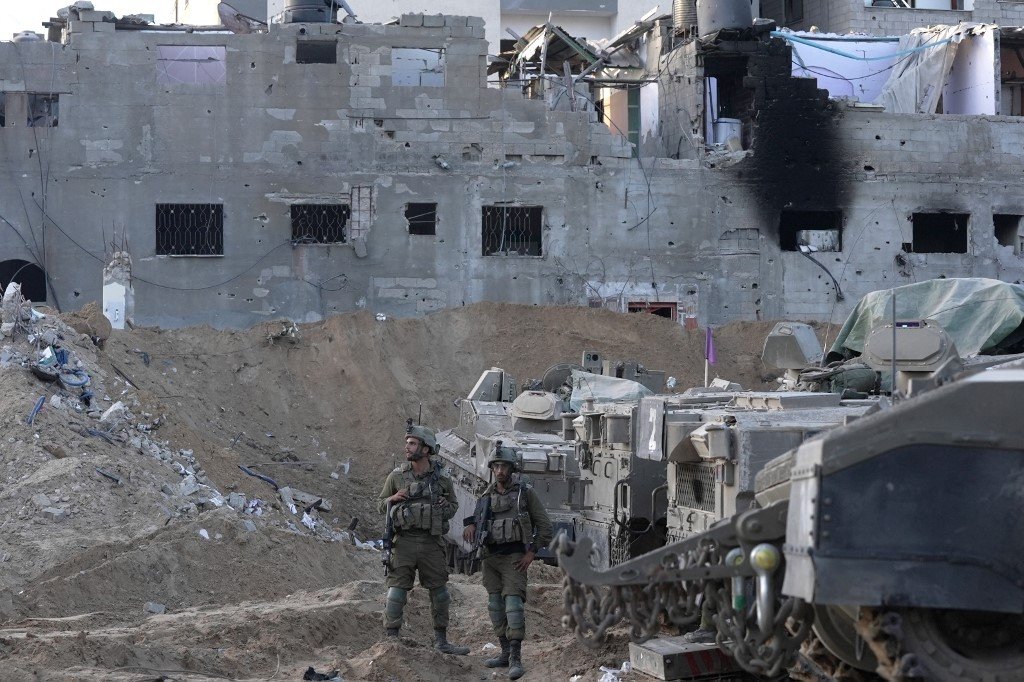 在加沙地带北部，以色列士兵和坦克周三在一栋满目疮痍，已成为废墟的建筑物前。（图取自法新社）